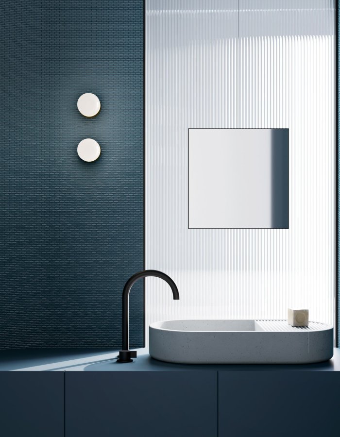 Executive bathroom with blue Mutina Phenomenon mosaic, oval stone basin and black tap
