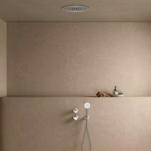 Floor-standing Flora bath mixer by Fantini beside a freestanding bath