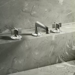 Wall-mounted Flora basin mixer by Fantini in Mokka above a stone basin