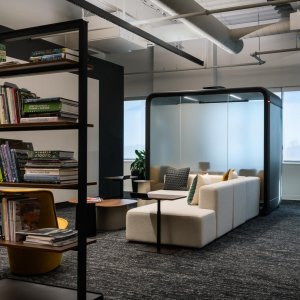 Dark Framery Four pod beside office workstations