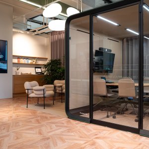 Dark Framery Six pod beside office workstations