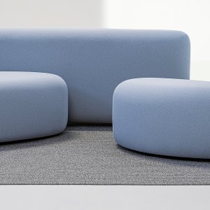 Small Lisse ottoman on its own, an irregular oval in stretch fabric