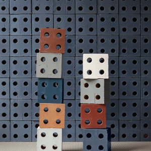 Stacked colourful Bloc blocks against a Bloc Blue wall