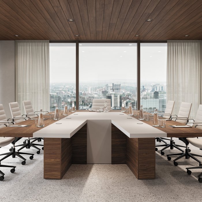 Oval Italian boardroom table with flush flip-up cable ports in a panelled London meeting room, twelve chairs drawn up